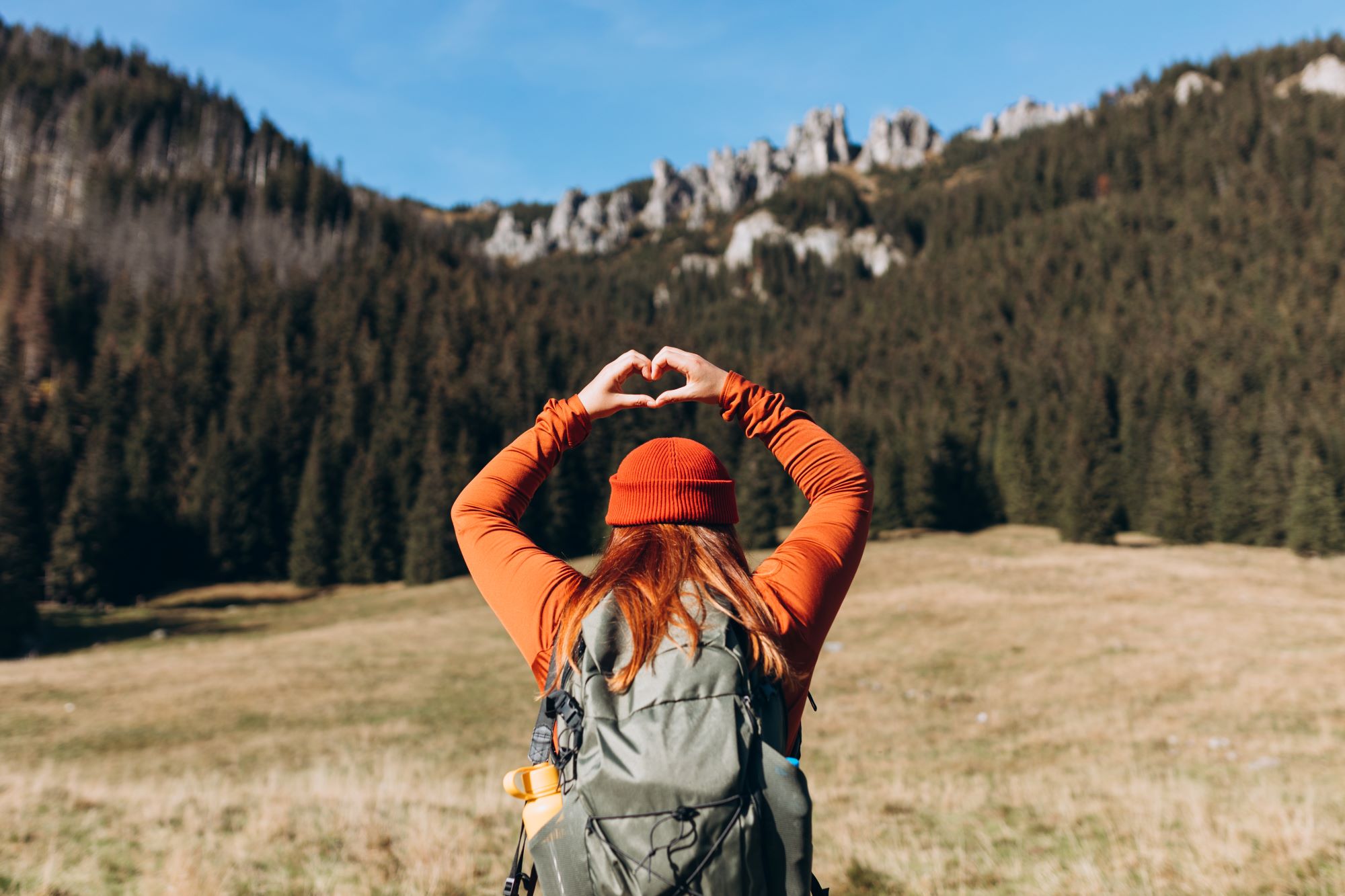 A hiker making a heart with her hands.